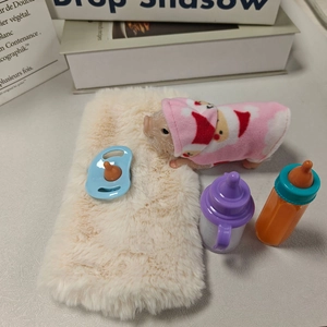 Miniature silicone piglet toy set with nursing bottles and pacifier on a faux fur rug
