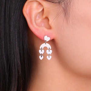 Bohemian silver heart tassel earrings in stainless steel on a female model