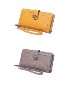 Close-up of mustard yellow and taupe long wallets with brogue detailing and wrist straps