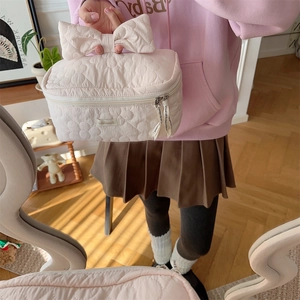 Gros plan de la trousse de toilette matelassée rose avec broderie florale