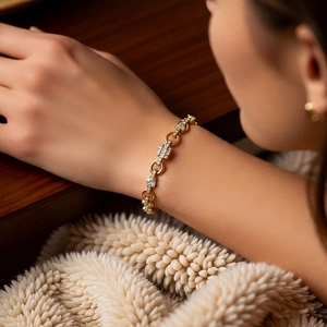 Detail of a gold-plated bracelet with geometric links and white cubic zirconia stones