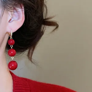 Gold-plated hoop earrings with triple red resin beads and sparkling crystal inlay