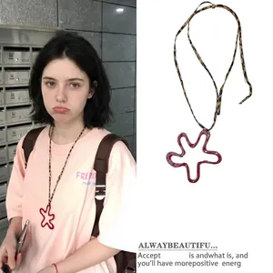 Detail view of a stylish red star-shaped flower pendant with leopard print cord necklace