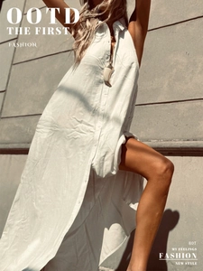 Detail of white sleeveless shirt dress featuring cotton fabric and natural texture