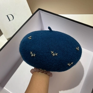 Close-up of navy blue wool beret featuring sparkling silver rhinestone star details
