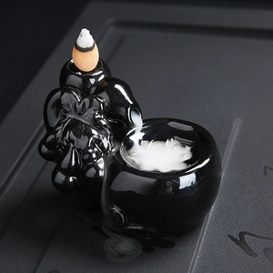 Black ceramic backflow incense burner with dragon pattern and flowing smoke effect