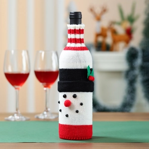 Macro detail of snowman knitted wine bottle cover with festive red and white wool textures