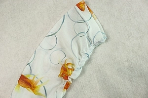 Detail of vibrant goldfish print on semi-transparent white mesh fabric with elastic hem