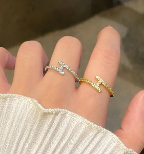 Vue détaillée d'une bague en forme de H sertie de zircons portée au doigt