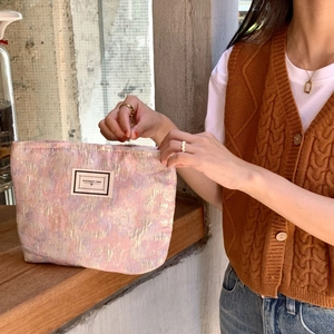 Detail of light pink jacquard makeup bag showing premium texture and Pleasant Time label