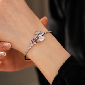 Close-up of butterfly cuff bracelet with pink zircon and white shell teardrop details