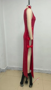 Detail of red sequin evening dress with side slit and decorative satin bows