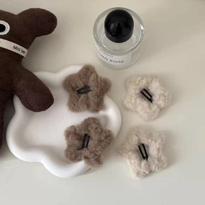 Cute plush star-shaped hair clips in beige and brown colors on a cloud tray
