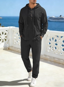 Detail of black linen men's leisure set showing drawstring hood and texture at seaside