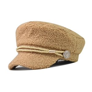 Detail of brown lamb wool newsboy cap with braided rope and vintage metal button