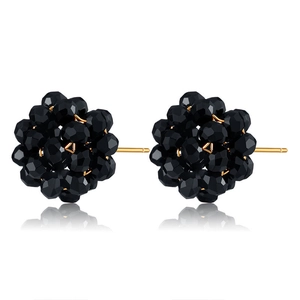 Detailed view of spherical stud earrings with black faceted beads and gold-plated pins