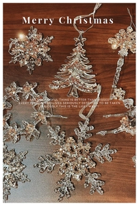 Macro shot of acrylic Christmas tree and snowflake ornaments with gold glitter finish
