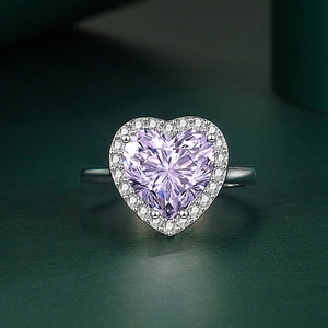 Bague avec pierre précieuse cœur violette et halo de zircons sur fond vert mat