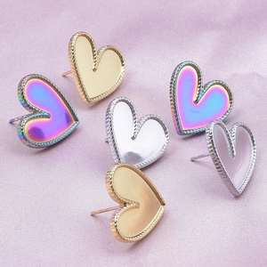 Detail view of heart-shaped stainless steel earrings in gold, silver, and rainbow finishes