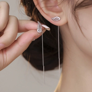 Elegant silver long tassel wing earrings with sparkling zircon crystals on a female model