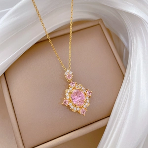 Macro view of luxurious pink oval gem pendant with crystal halo on gold chain