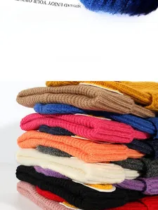 Close-up of stacked colorful knit beanies showing thick texture and vibrant assorted colors