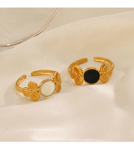 Close-up of gold flower open rings with black and white drip oil on silk background