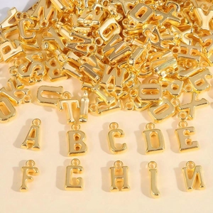 Macro shot of gold metal letter pendants showing alphabet variety and glossy finish