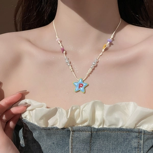 Nahaufnahme der Seestern-Halskette mit blauem P-Anhänger und bunten Perlen am Model