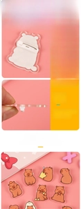 Detailed macro view of the acrylic capybara pin back with a white safety metal clasp