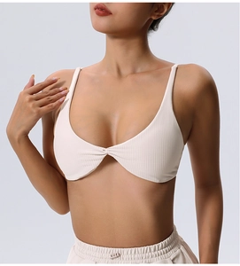 Detailed view of beige ribbed sports bra featuring twist front knot and thin shoulder straps