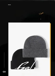 Close-up of soft knitted wool texture on grey and black winter beanie hats for outdoors