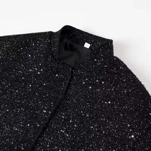 Detailed view of neckline and shoulder on black sequined tweed jacket with a stand collar