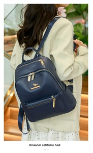 Detail view of dark blue leather backpack with gold zipper and kangaroo logo emblem