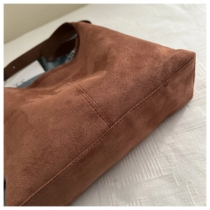 Close-up of brown suede tote bag showing premium stitching and textured velvet finish