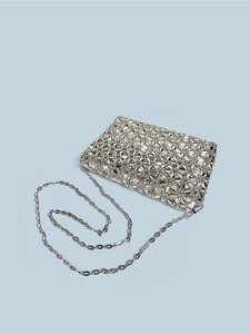 Close-up of silver hollow woven evening bag with metallic beads and chain strap