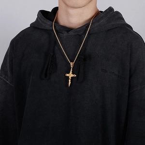 Mann trägt goldene Kreuzhalskette mit hohlgearbeitetem Muster aus Edelstahl-Stil
