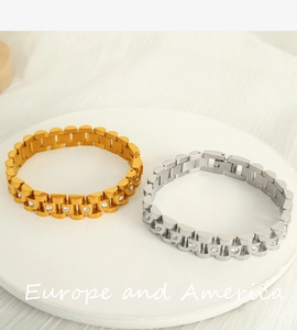 Macro detail of gold and silver watch-style bracelets with white zircon inlays on stone