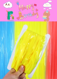 Detail of yellow macaron tinsel fringe curtain roll for birthday party background decor
