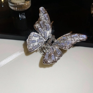 Macro detail of silver butterfly hair claw clip with sparkling cubic zirconia stones