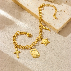 Gold-plated stainless steel chain bracelet with celestial charms on sandy background