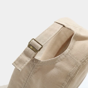 Detail of adjustable khaki canvas strap and vintage metal buckle on a military flat cap