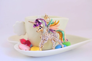 Détail d'un porte-clés licorne en émail coloré avec des strass blancs étincelants
