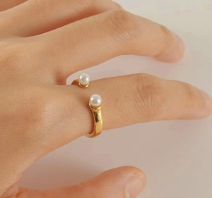 Detail of adjustable gold stainless steel ring featuring dual white pearls on hand