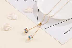 Detailed Y-shaped gold necklace featuring two crystal-encrusted spheres and slider bead