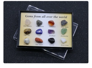 Polished natural crystal specimens in a black display box with English labels