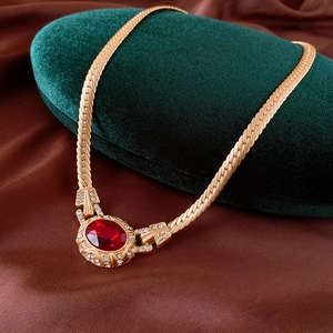 Makroaufnahme der goldenen Vintage-Schlangenkette mit großem ovalen roten Kristallanhänger