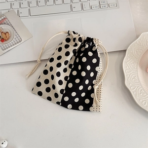 Close-up of a polka dot drawstring pouch on a laptop for storage and organization