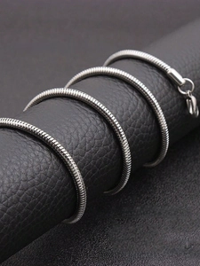 Detailed close-up of a silver-toned stainless steel snake chain necklace with lobster clasp