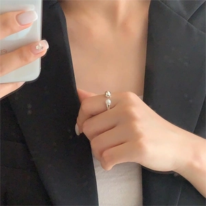 Detail of adjustable 925 silver ring featuring pearl and metal bead on a hand